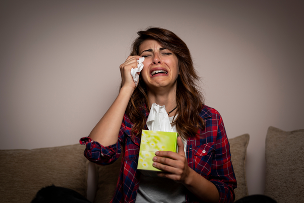 Woman sat on sofa crying