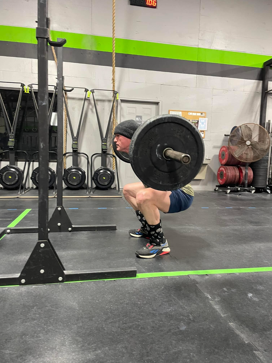 Dr. Jason from Vanguard Chiropractic in Tulsa’s Brookside area performing weighted back squats at a CrossFit gym, demonstrating the importance of strength, balance, and spinal stability.