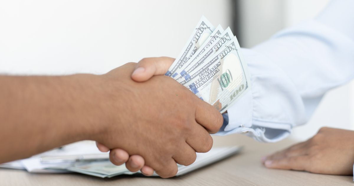 man giving dollar money to another man man giving dollar money to another man