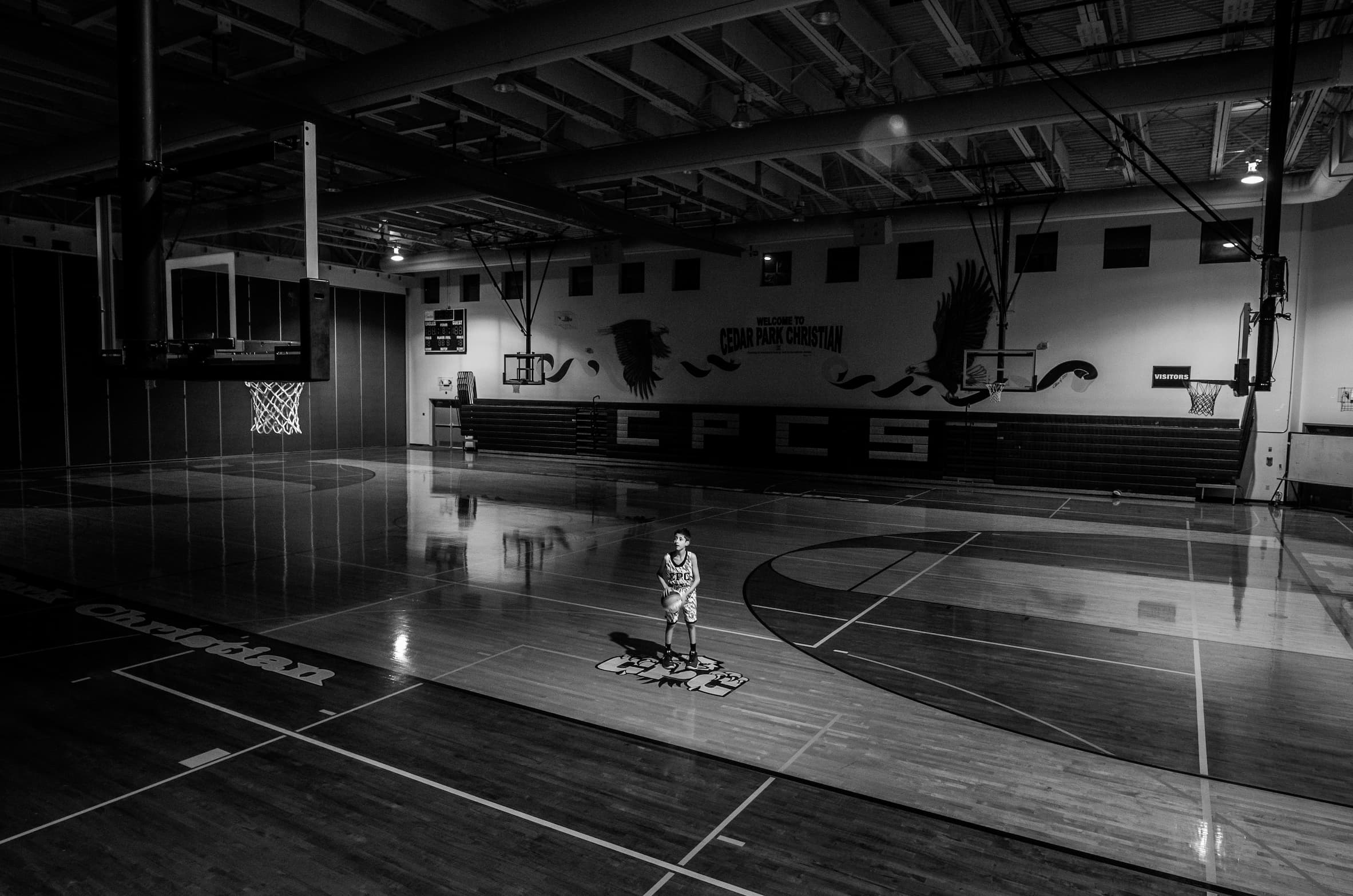 Basketball player practicing alone in gym
