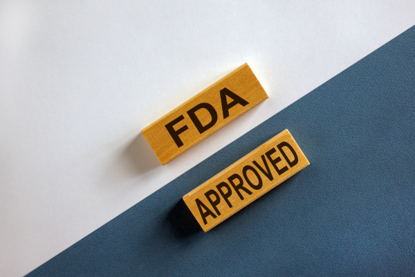 Two small wooden blocks together that write, " FDA Approved" when placed together