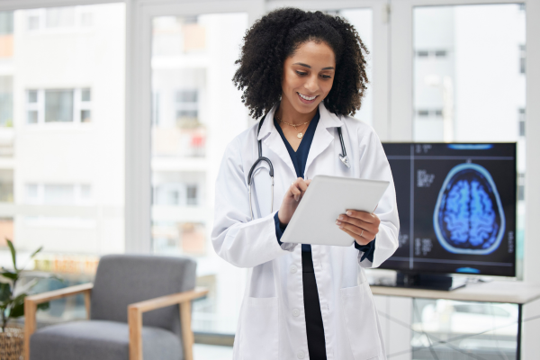 Happy female African American doctor looking over scans of a patients brain