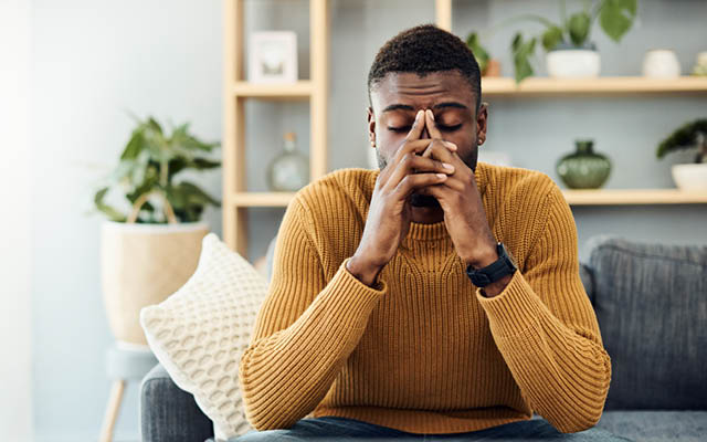 Young African American Adult sitting down in a  depressed/stressed nature