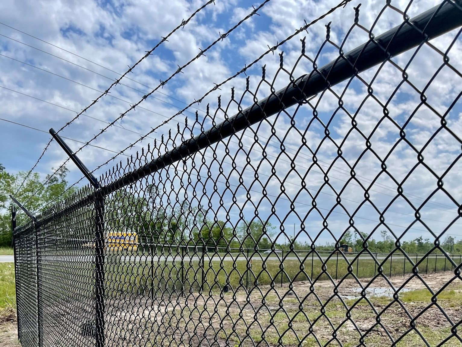 a chain linked fence with barbed wire