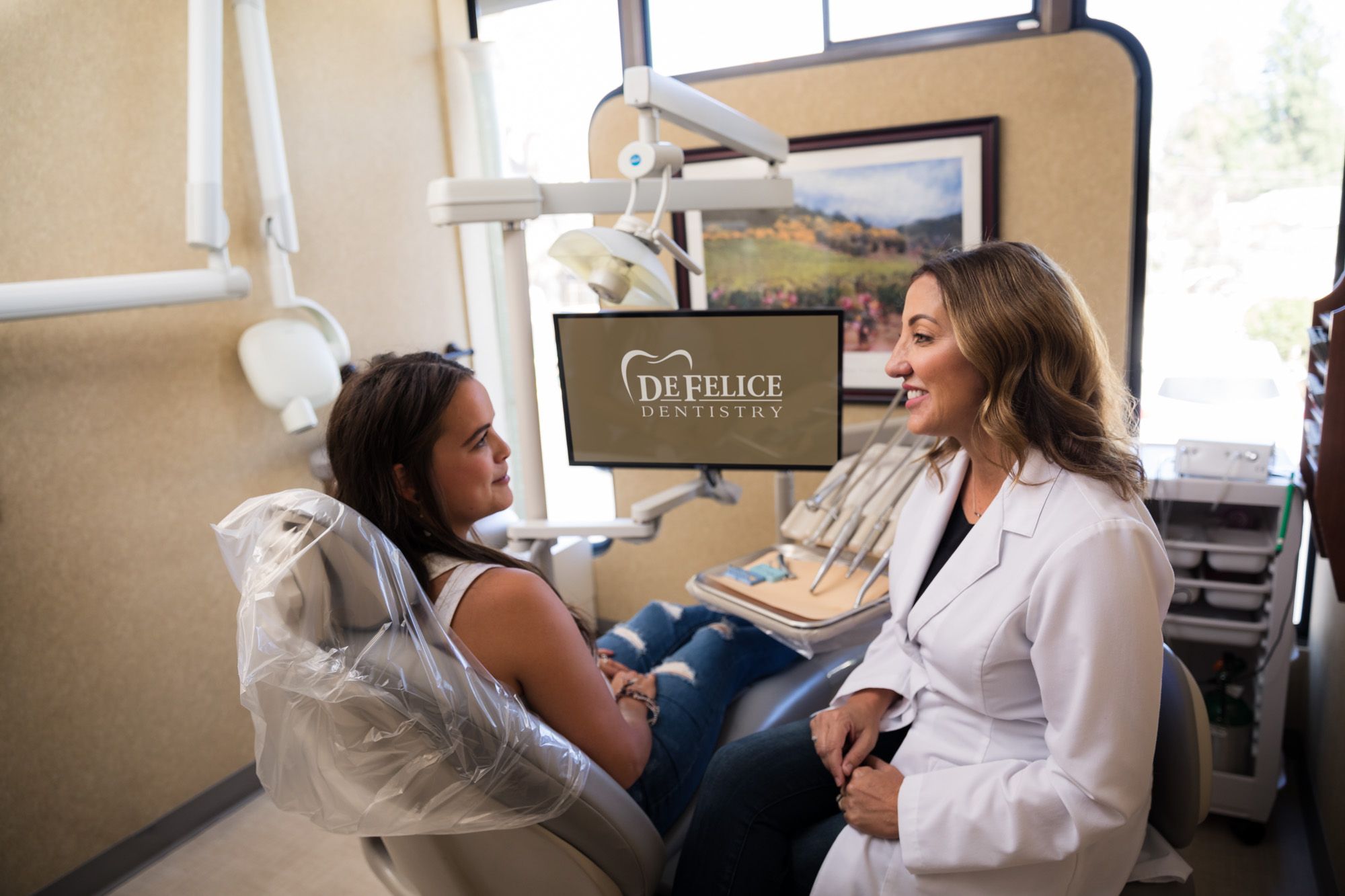 dentist and patient smiling in an exam room for a branding photoshoot dentist and patient smiling in an exam room for a branding photoshoot