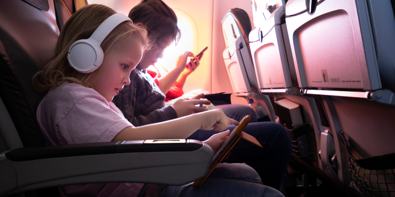 child wearing headphones watching a movie on a tablet child wearing headphones watching a movie on a tablet