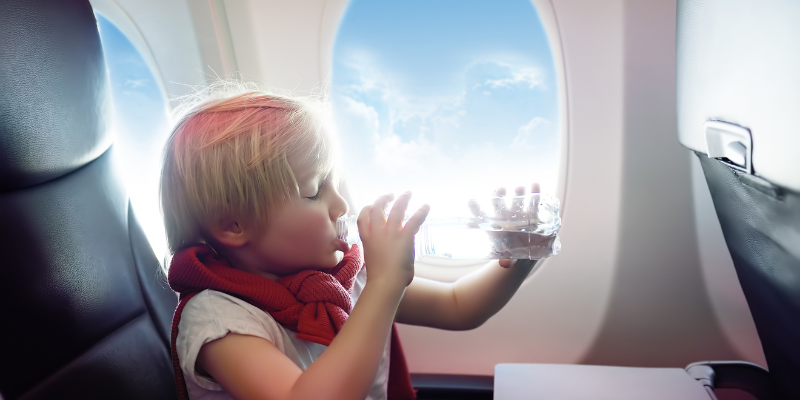 toddler drinking from a bottle during takeoff toddler drinking from a bottle during takeoff