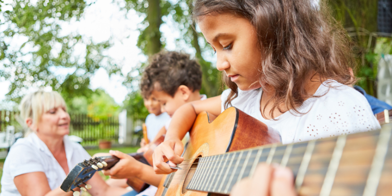 kid playing a guitar at the resort kid playing a guitar at the resort