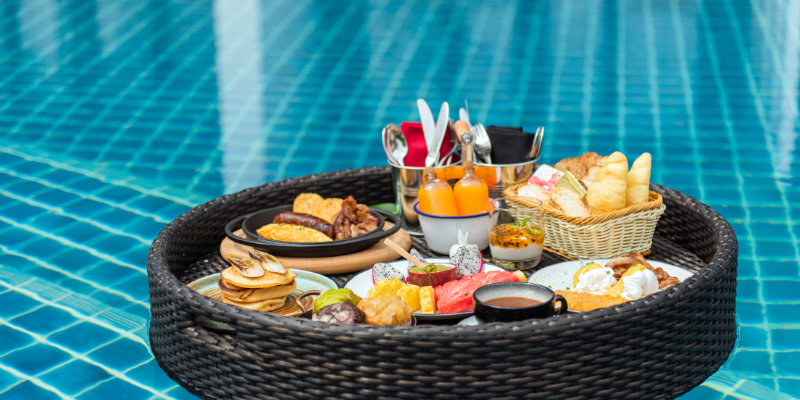 couple enjoying a floating breakfast in their private pool villa couple enjoying a floating breakfast in their private pool villa