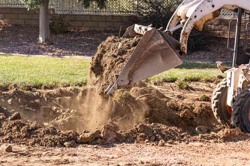 Excavator grading a residential property