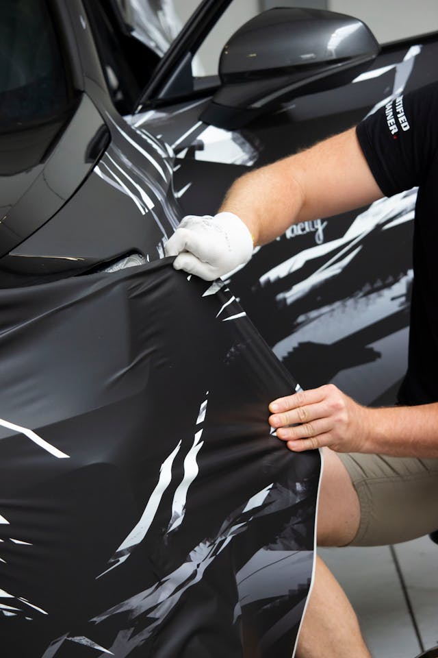 Premium vinyl wrap being professionally applied to vehicle, showcasing color transformation and paint protection