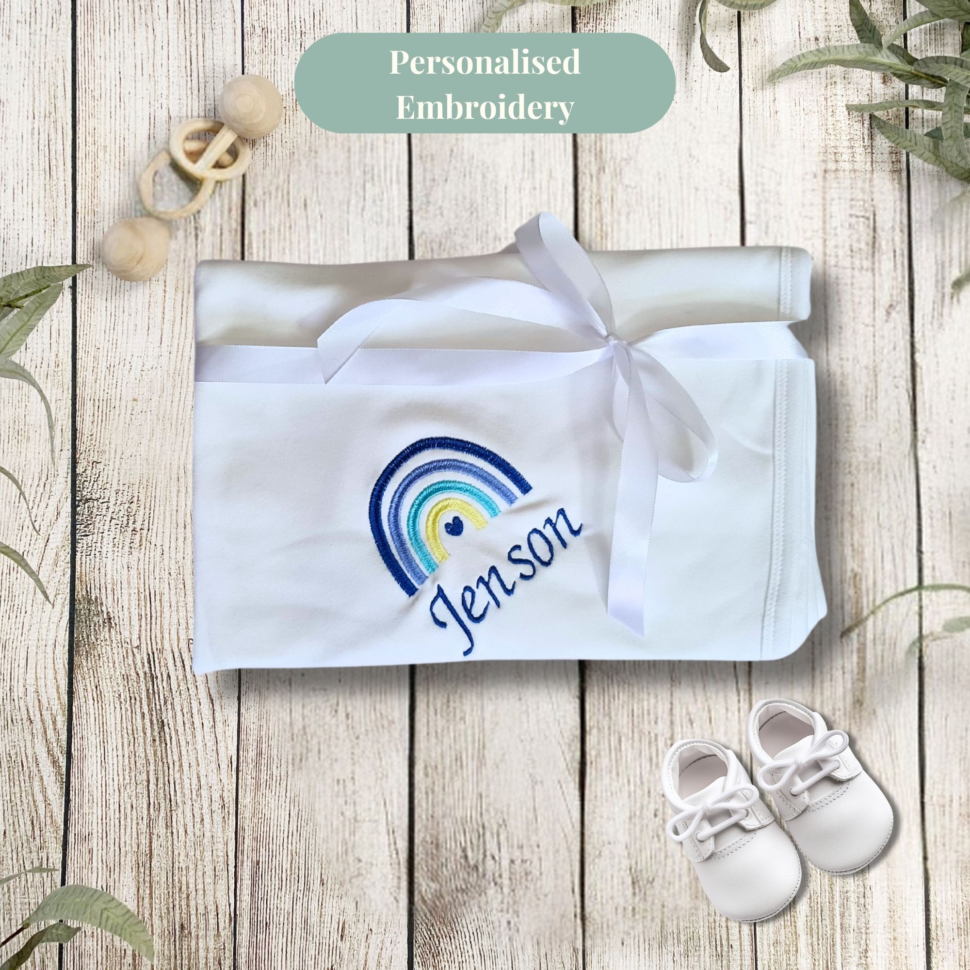 Personalised baby blanket featuring the baby name and rainbow in blue
