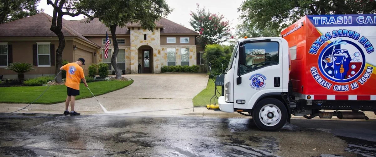 Power washing a concrete driveway to remove dirt and grime.