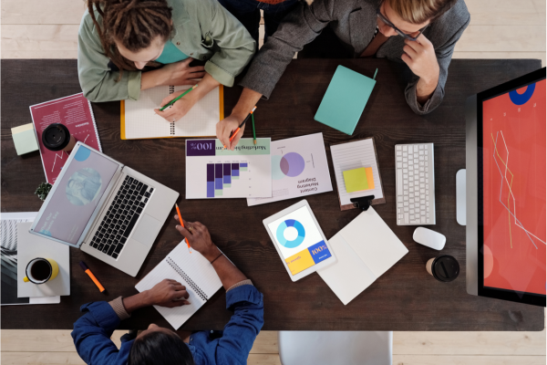 Executives collaborating in a modern workspace, reviewing a strategic diagram on a large screen, emphasizing teamwork and long-term decision-making. Executives collaborating in a modern workspace, reviewing a strategic diagram on a large screen, emphasizing teamwork and long-term decision-making.