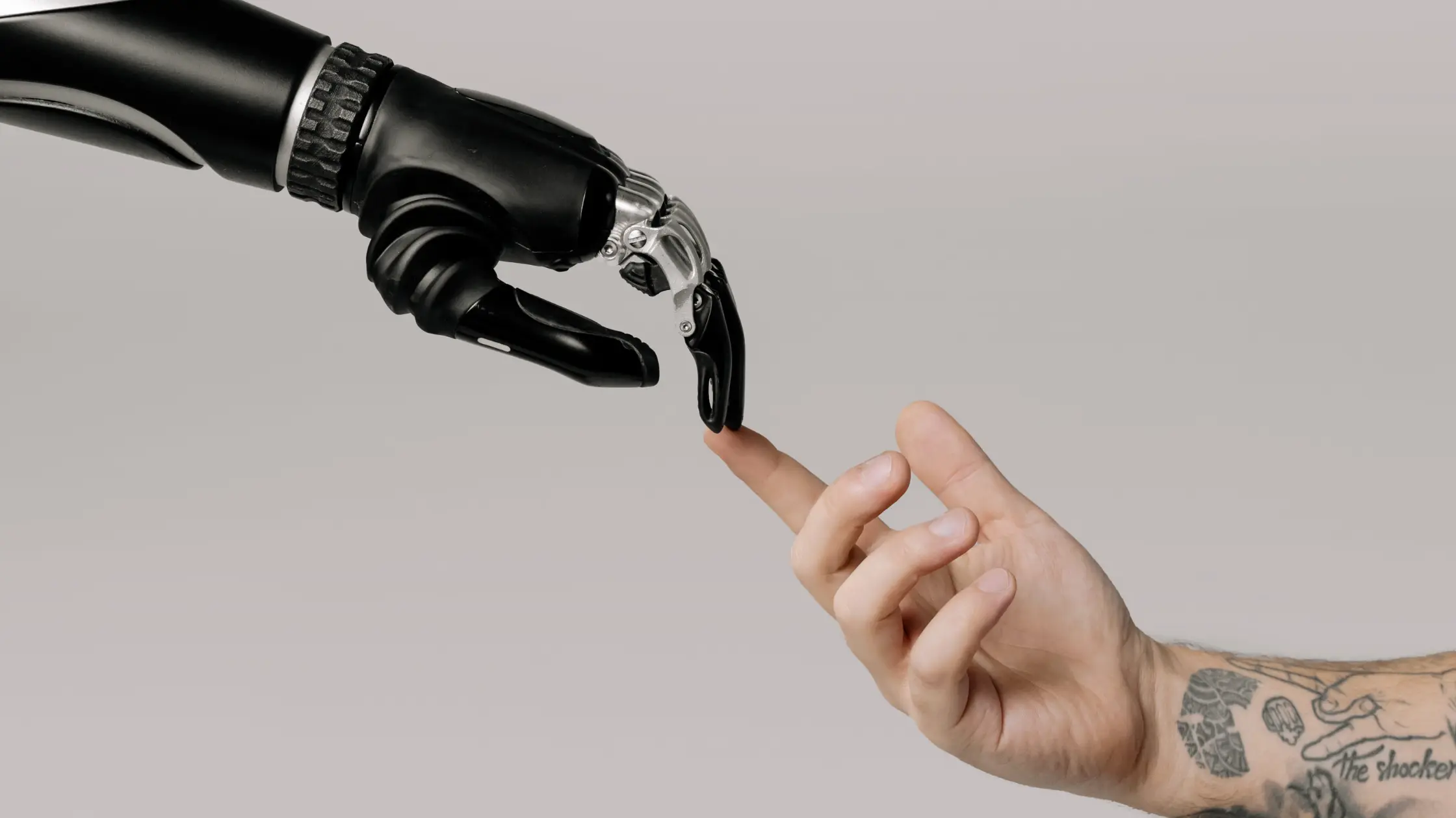 Robot hand and finger touching a human hand finger