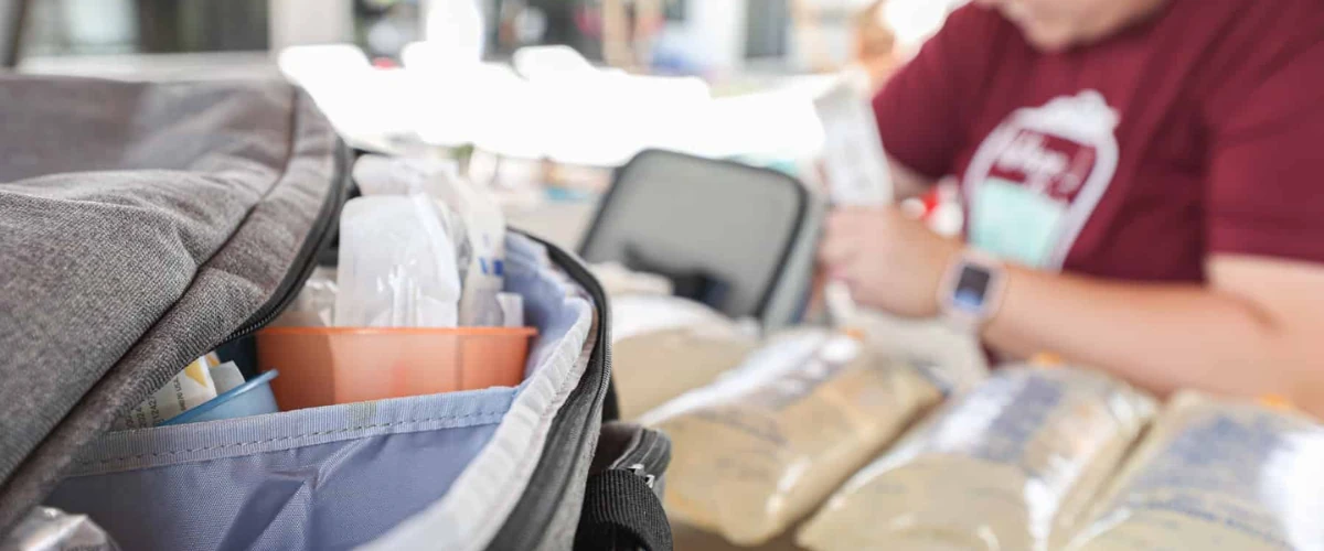 Medical professional organizing IV therapy supplies in a mobile setup. Medical professional organizing IV therapy supplies in a mobile setup.
