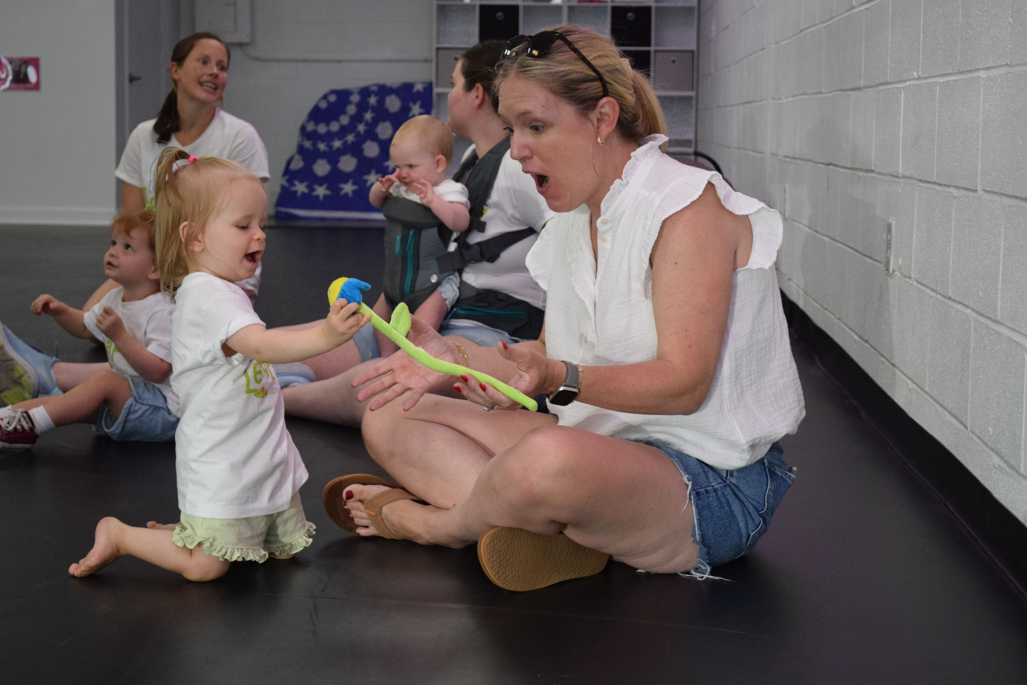 women and toddlers sitting together and smiling in a dance class women and toddlers sitting together and smiling in a dance class