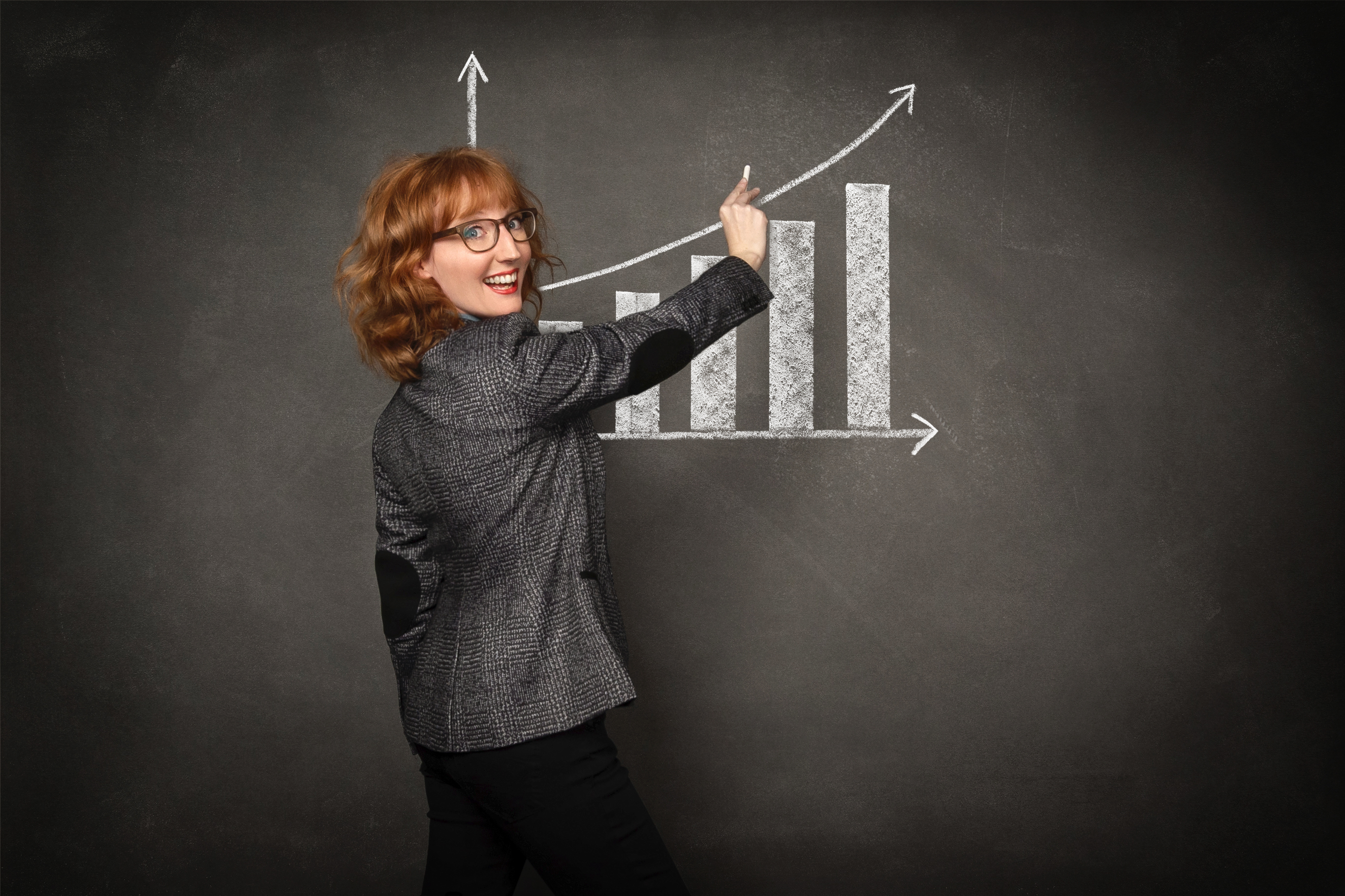 Woman drawing growth chart on chalkboard