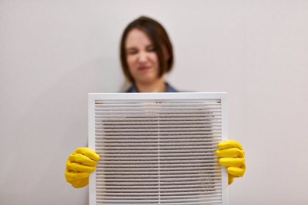 Woman holding dirty air duct filter