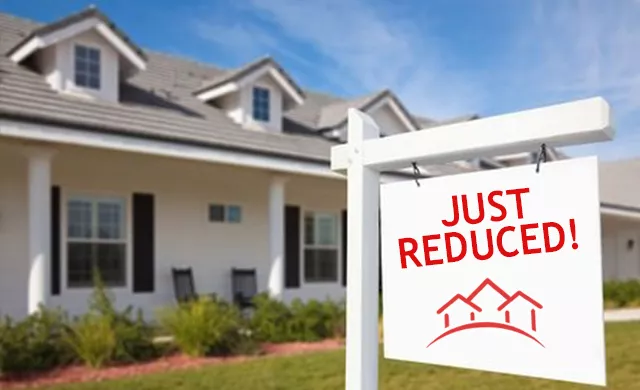 price reduction sign in front of a house
