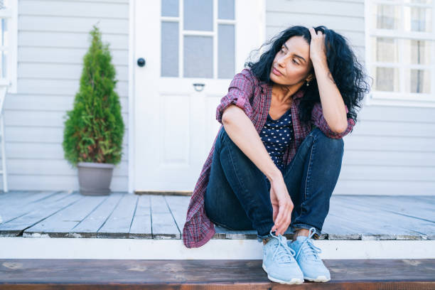 lady sitting in front of house stressed out