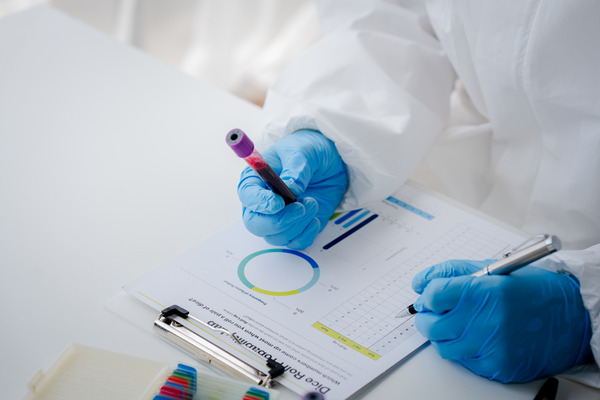 a lab technician carefully examines data printed on a paper, analyzing trends and patterns for insights