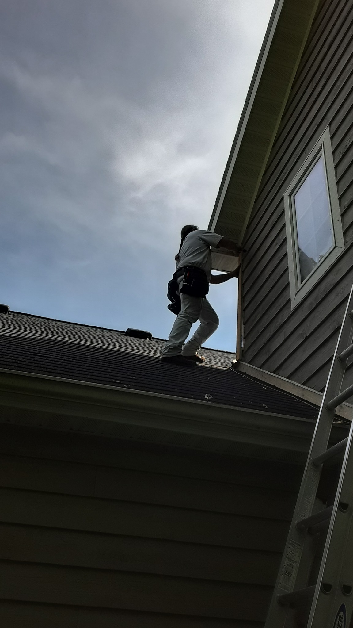 Scott on a customer's roof repairing their home