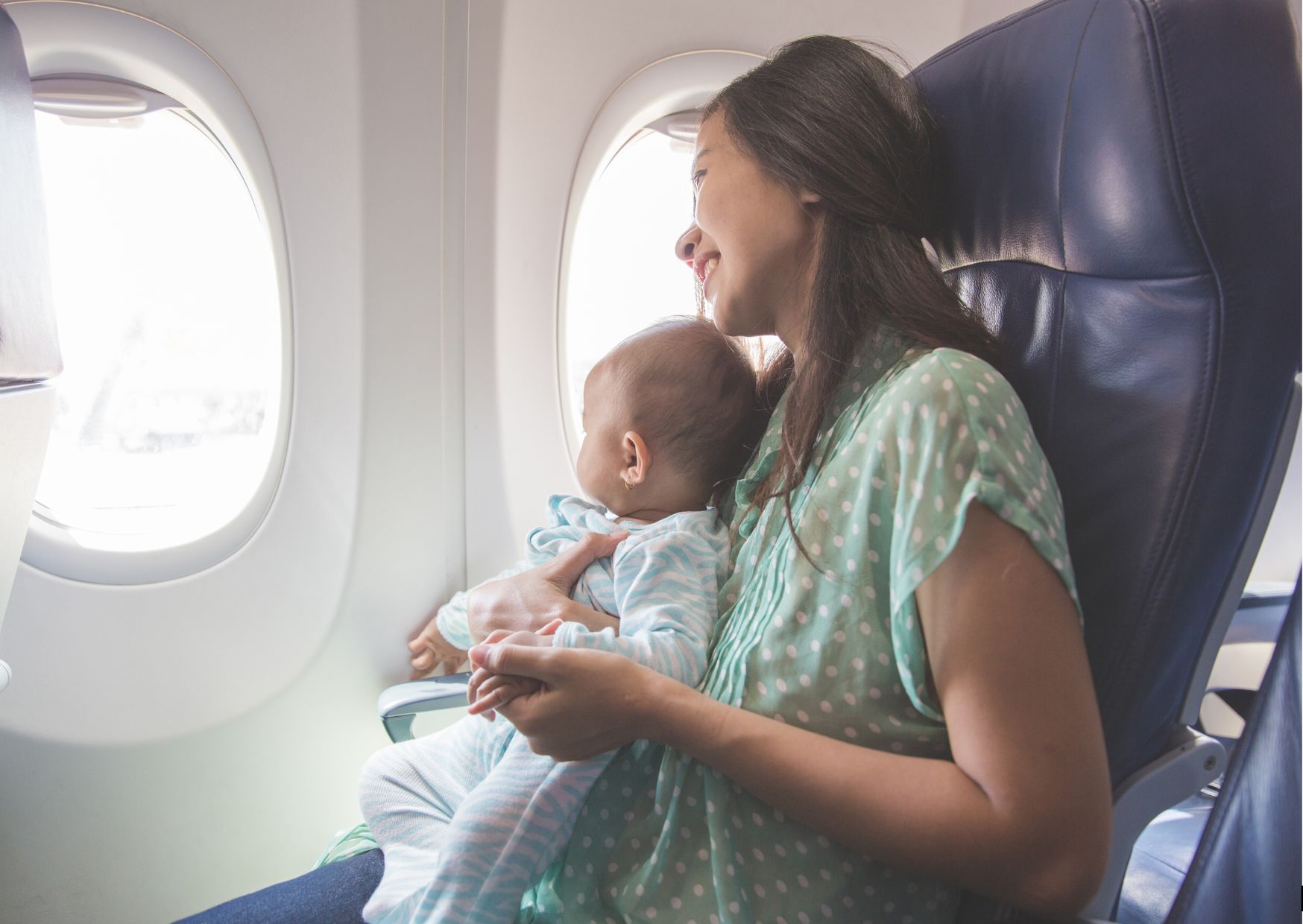 mom holding baby on the airplane traveling with baby mom holding baby on the airplane traveling with baby