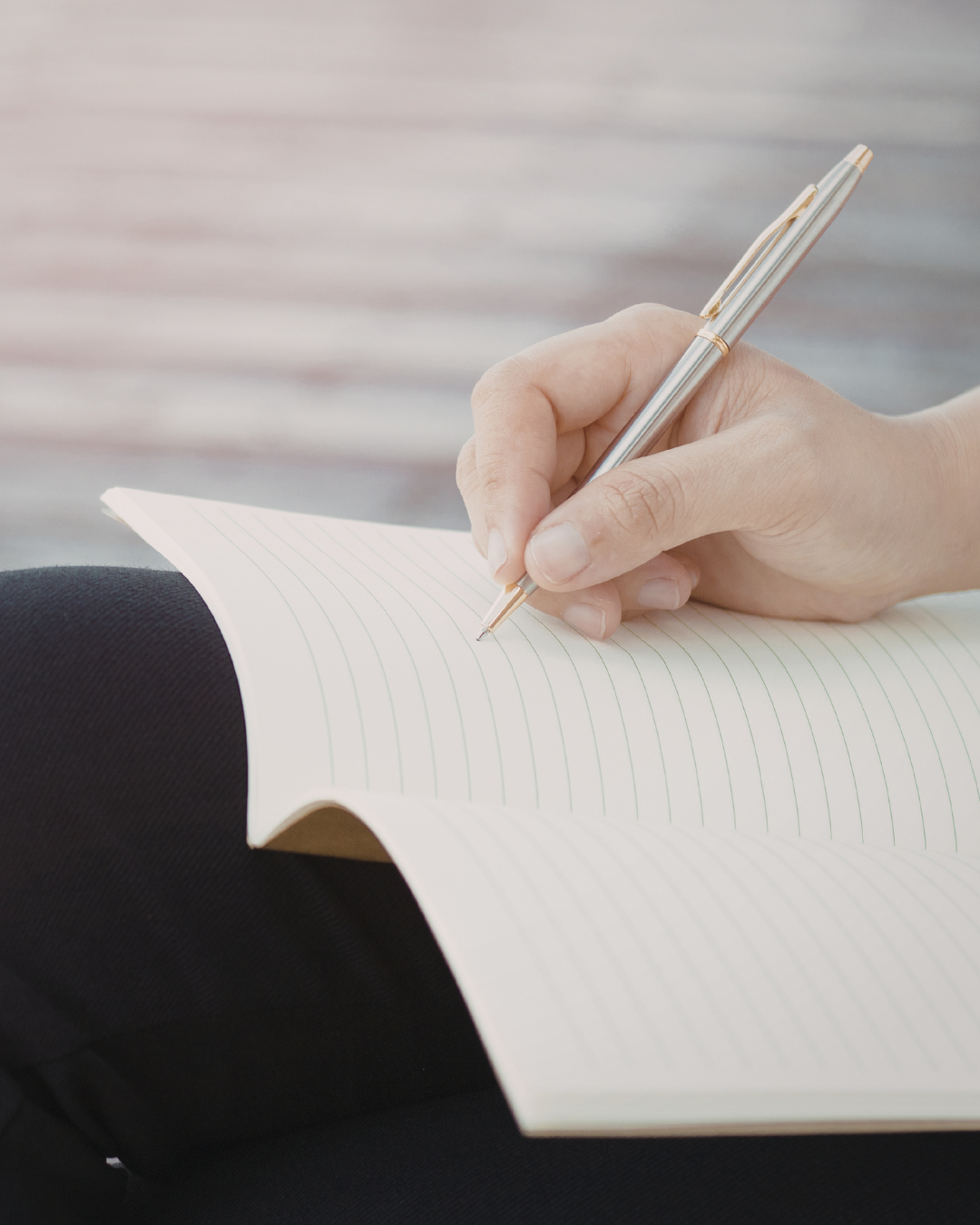 A person pausing before writing, pen hovering above paper A person pausing before writing, pen hovering above paper