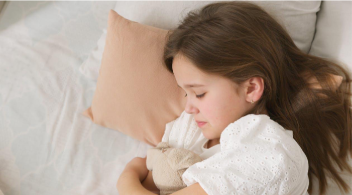 A young girl peacefully sleeping in her bed, embracing a soft toy A young girl peacefully sleeping in her bed, embracing a soft toy