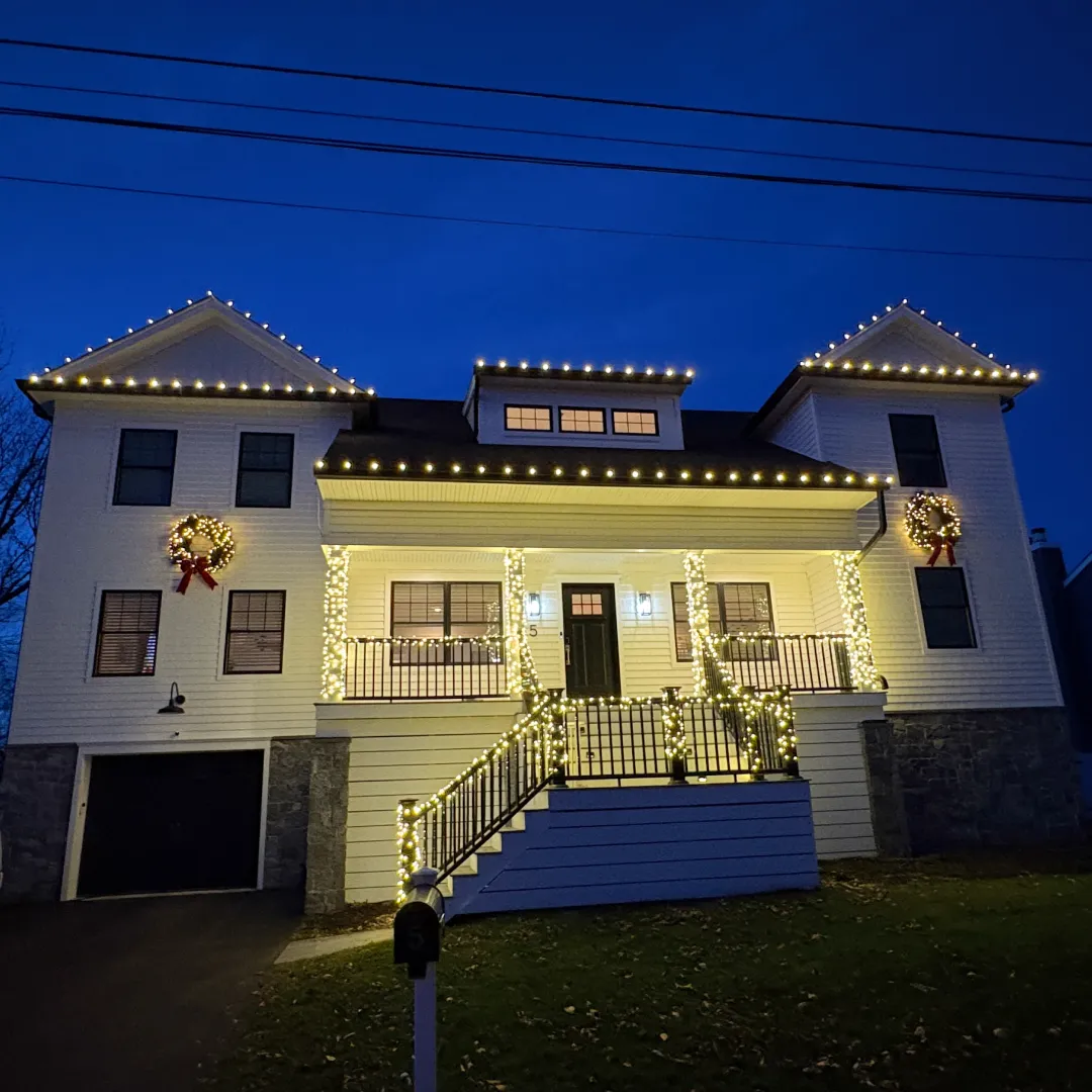 Professionally decorated New Jersey home with Christmas lights at dusk