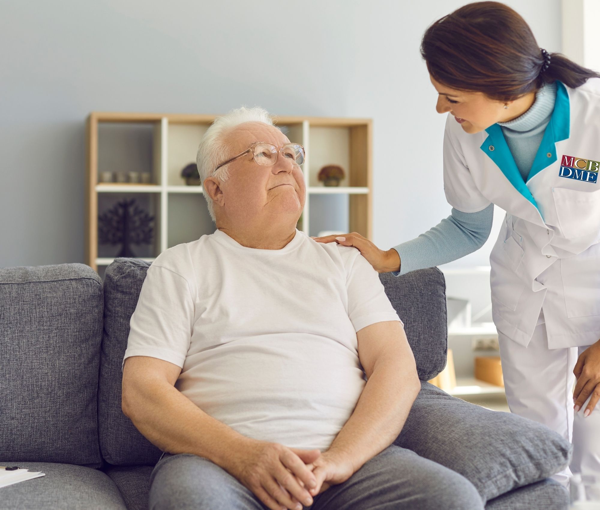 nurse assisting older gentleman seated 