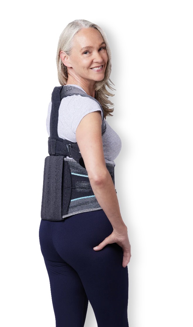 Woman wearing an Aspen back brace showing its flexibility