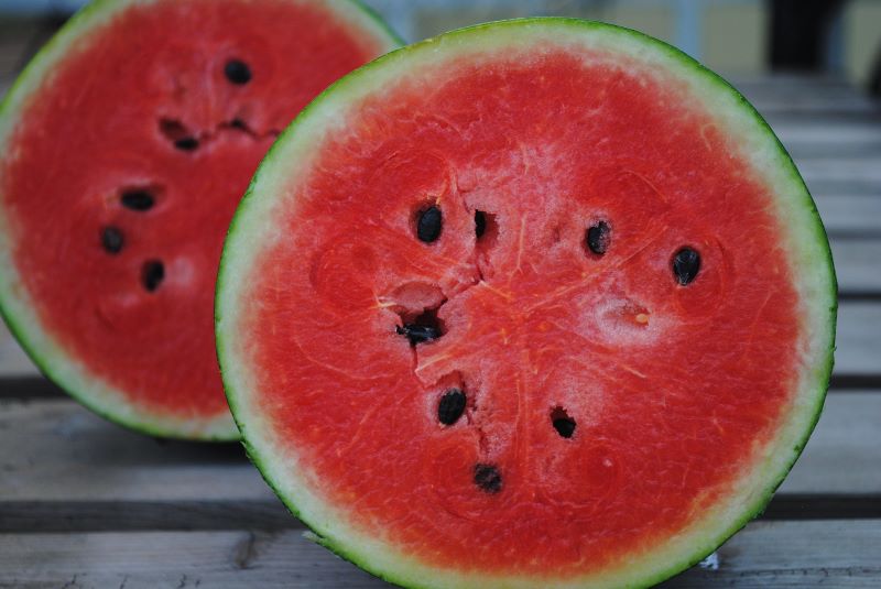 sliced watermelon showing pink inside and pips