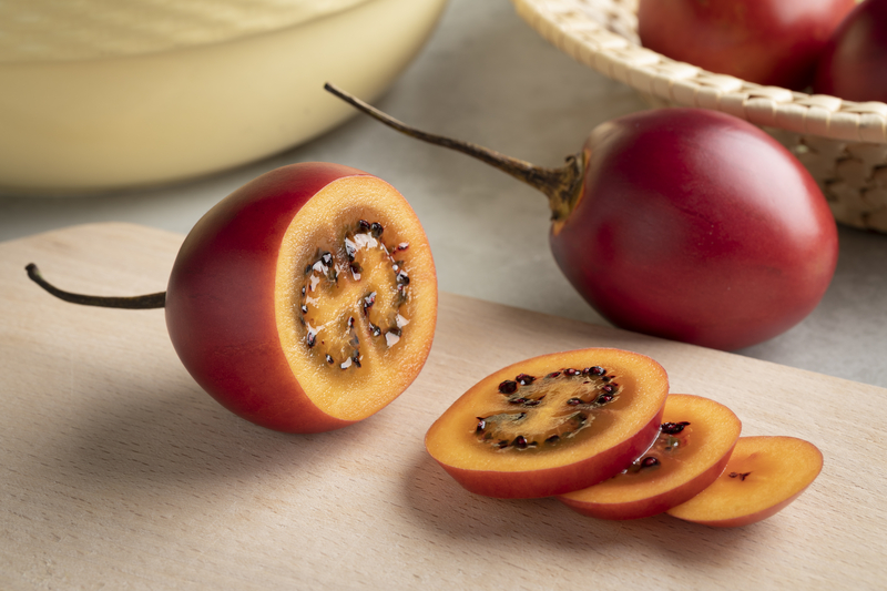 a sliced tamarillo on a wooden board a sliced tamarillo on a wooden board