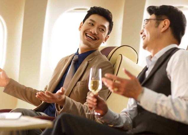 high net worh individuals enjoying wine on a plane