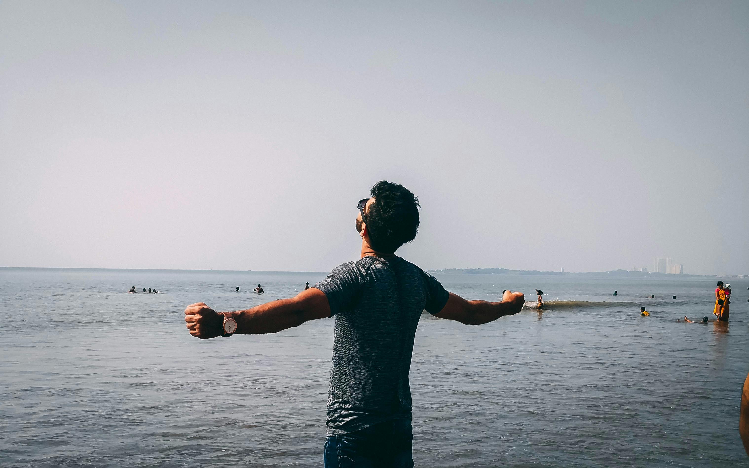 a man feeling free by the ocean and leaning into his true potential