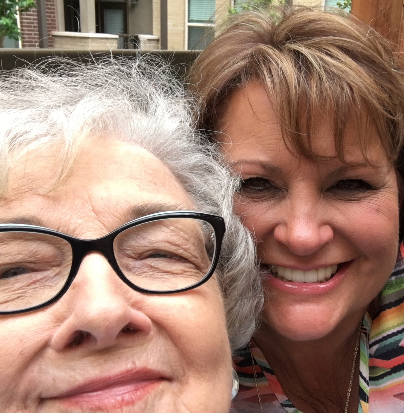 Photo of the author with her mother in later years, both smiling for the camera while quietly carrying the hidden pain of a life touched by bipolar disorder.