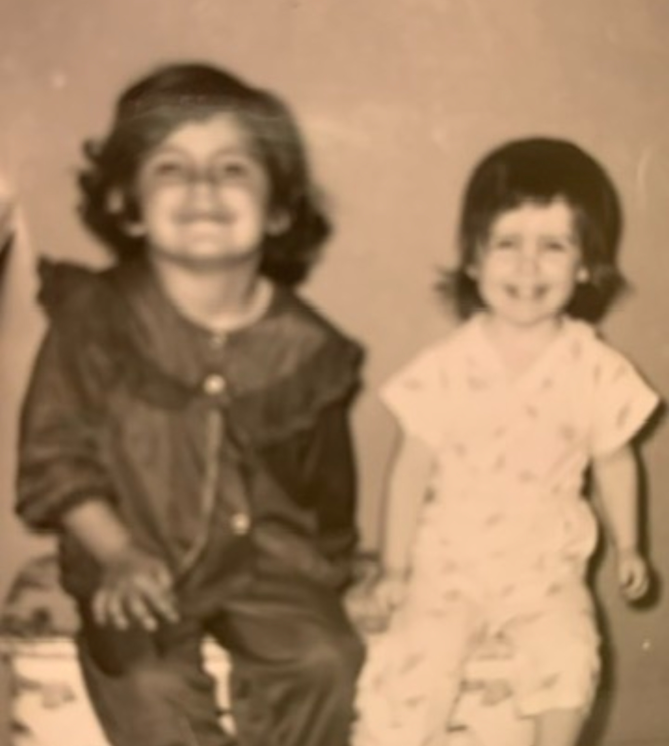Childhood photo of two sisters, with the older protecting the younger during their mother’s manic bipolar episodes, symbolizing love, resilience, and survival.