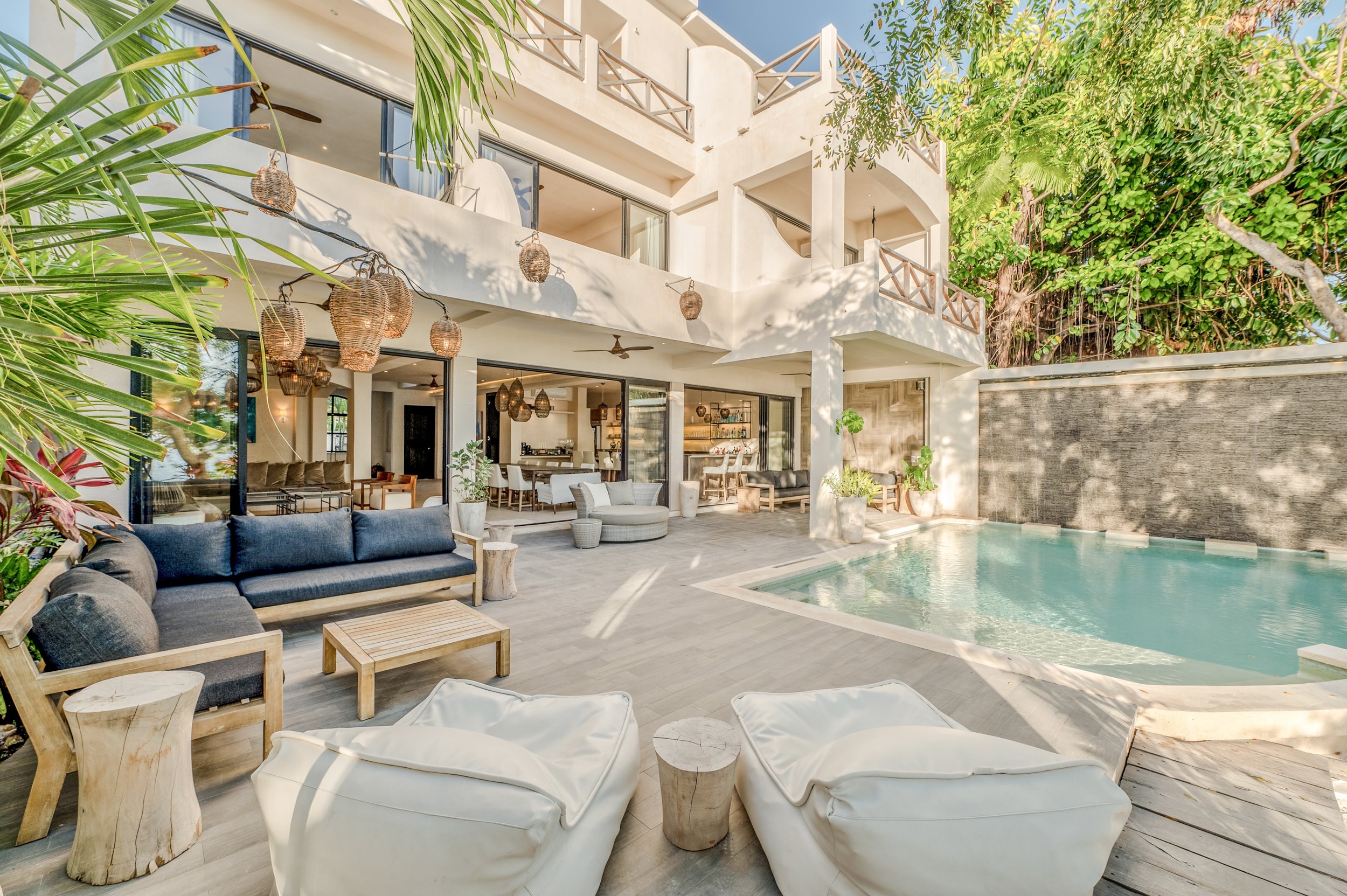 Luxury oceanfront villa featuring a pool, cushioned seating, natural wood décor, and hanging woven lanterns — the upgraded retreat location.” Luxury oceanfront villa featuring a pool, cushioned seating, natural wood décor, and hanging woven lanterns — the upgraded retreat location.”