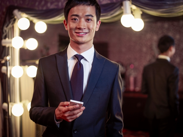 Portrait of young man in new suit in traditional tailors shop