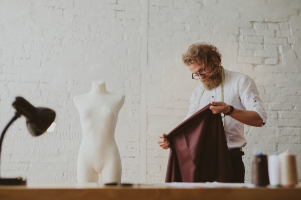 Tailor looking at piece of fabric