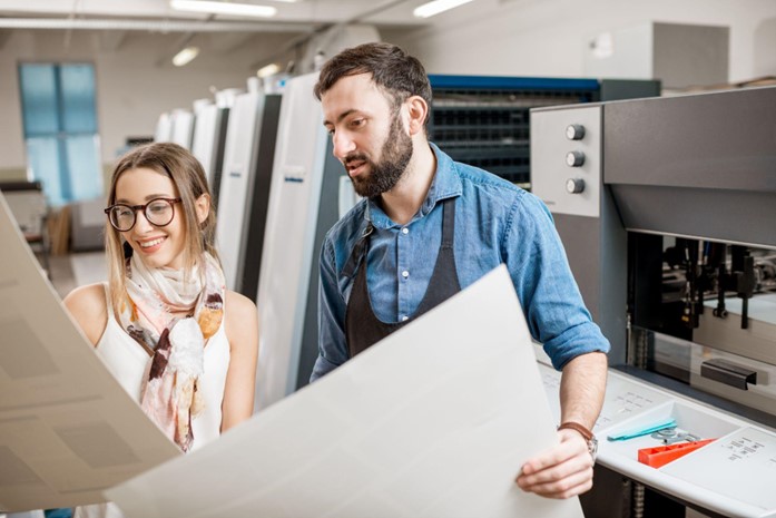 print manager and client reviewing a physical print proof.