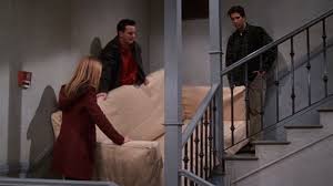 Rachel, Ross, and Chandler trying to carry a settee upstairs from Friends