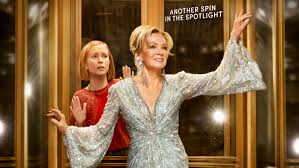 Deborah and Ava stood in front of a revolving door from Hacks