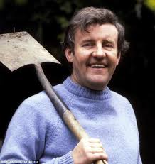 Character of Tom smiling, holding a spade on his shoulder