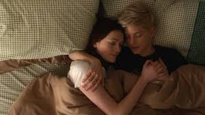 Mae Martin and Kate Ritchie laying in bed together in the show Feel Good Mae Martin and Kate Ritchie laying in bed together in the show Feel Good