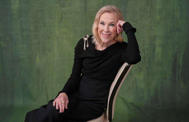 Catherine O'Hara looking stunning sitting on a chair looking into the camera