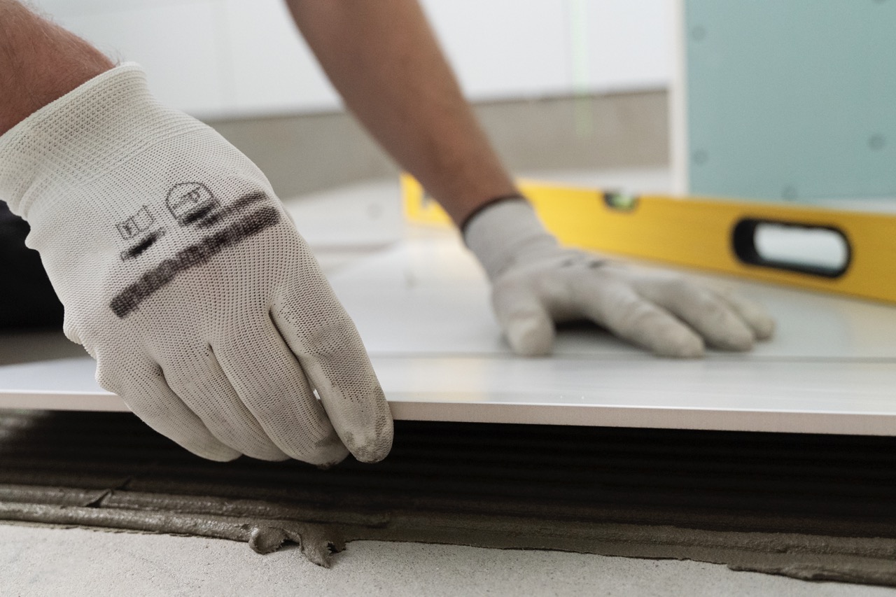 A person laying tiles down