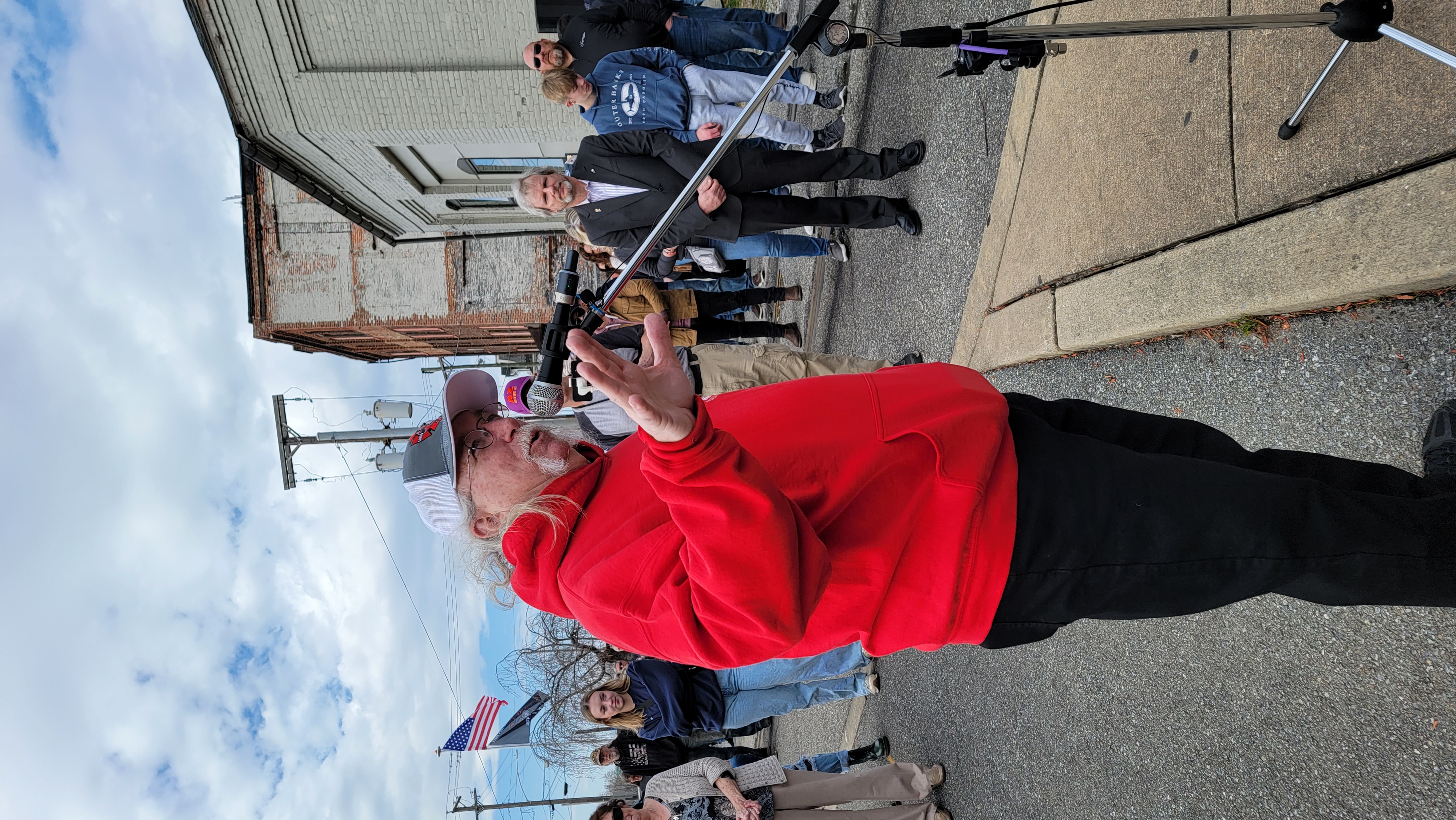 Community member sharing a testimonial during the memorial dedication